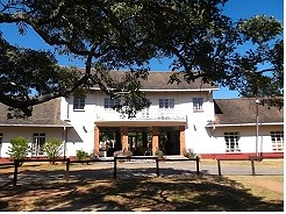 The Cloisters, the Trust's main building: a white building with a covered entrance, shaded by large trees
