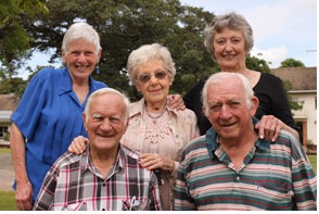 Five residents smiling together in the garden